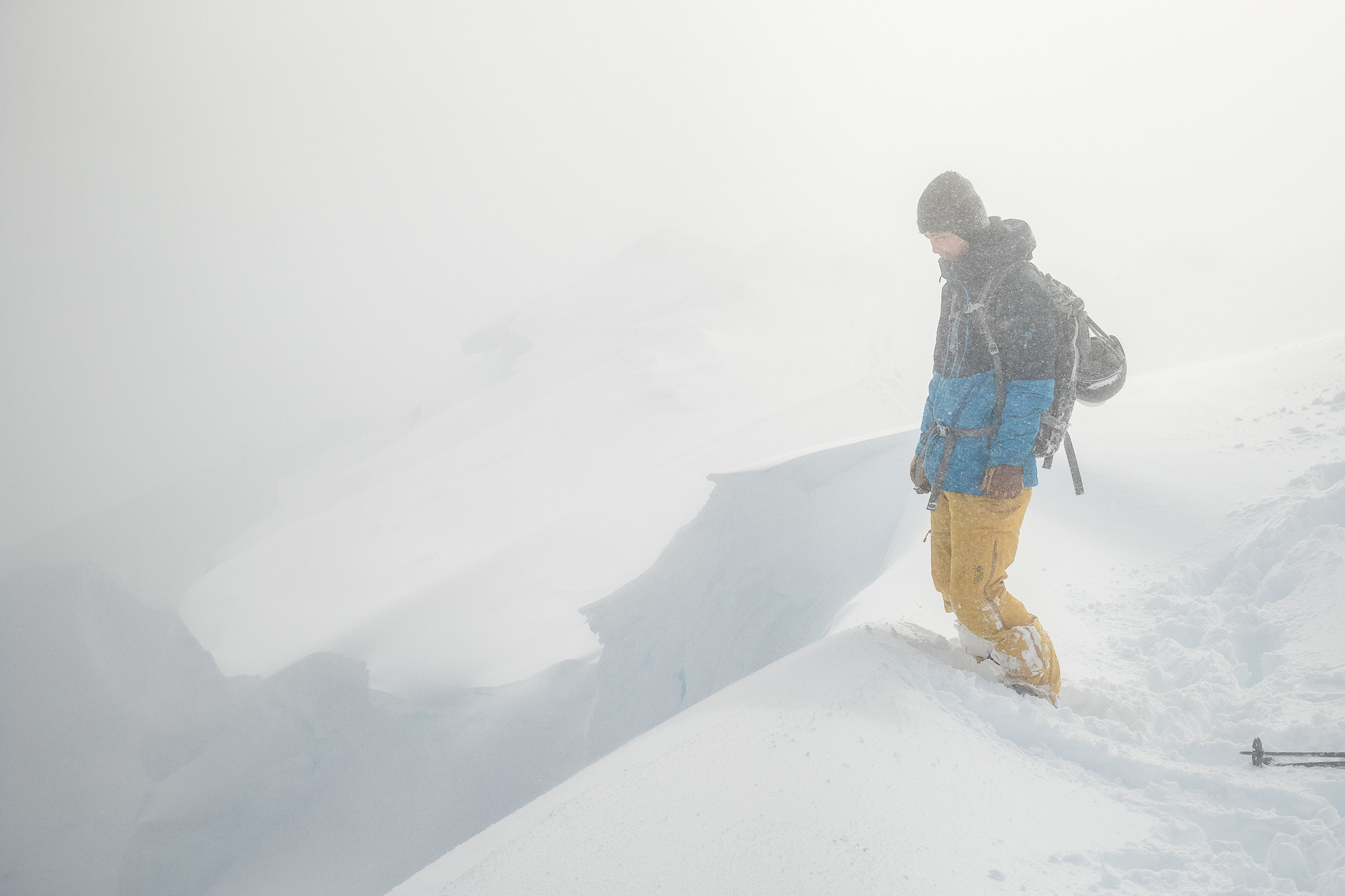 a skier standing on snow near cornice