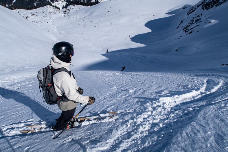 High alpine perspective looking down the lower snow slopes and gullies toward the valley floor in the Blackcomb backcountry